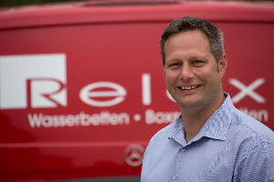 Inhaber vor dem Relax Wasserbetten Firmenwagen